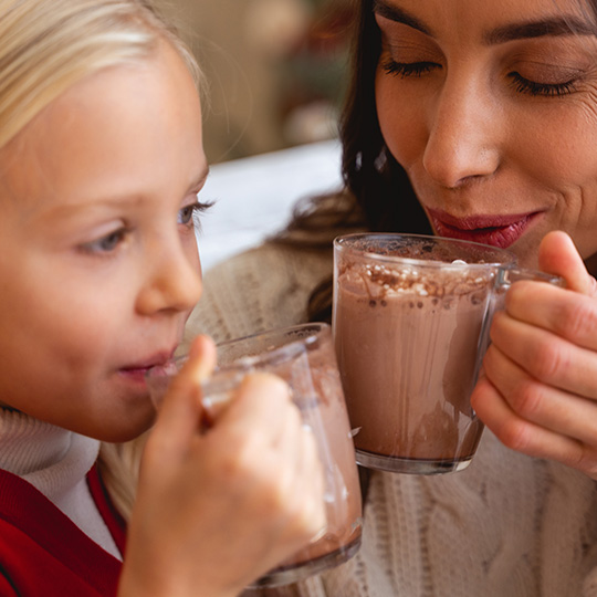 mother and daughter drinking cocoa together